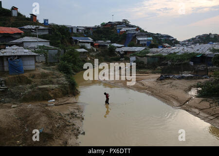 Cox's Bazar, Bangladesh: UN RIFUGIATO Rohingya ragazza raccoglie dirking fresca acqua, attraversando il canale in un campo di rifugiati in Ukhia, Cox's Bazar, Bangladesh il 13 ottobre 2018. Più di un milione di Rohingya persone vivono in bambù e telone e rifugi in foglio. Più di mezzo milione di rifugiati Rohingyas dal Myanmar è stato di Rakhine, sono fuggiti in Bangladesh dal mese di agosto 25, 2017 secondo l ONU. © Rehman Asad/Alamy Stock Photo Foto Stock