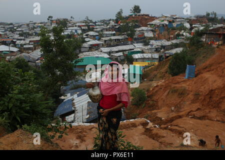 Cox's Bazar, Bangladesh: UN RIFUGIATO Rohingya donna visto porta acqua potabile in un campo di rifugiati in Ukhia, Cox's Bazar, Bangladesh il 13 ottobre 2018. Più di un milione di Rohingya persone vivono in bambù e telone e rifugi in foglio. Più di mezzo milione di rifugiati Rohingyas dal Myanmar è stato di Rakhine, sono fuggiti in Bangladesh dal mese di agosto 25, 2017 secondo l ONU. © Rehman Asad/Alamy Stock Photo Foto Stock