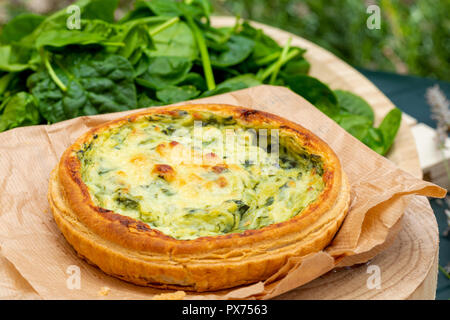 Close-up di quiche con verdure fresche. Sfondo in toni di verde. Rustico e aspetto del paese. Foto Stock