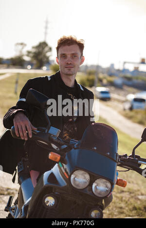 Bello motociclista seduto sulla moto Foto Stock