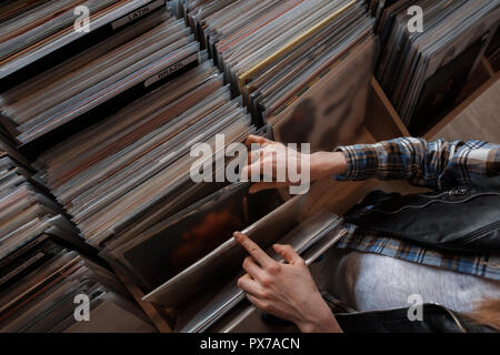 Mani femminili navigando dischi in vinile in un negozio Foto Stock