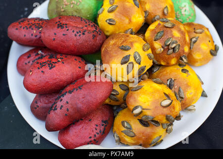 Freschi Fatti in casa panini hamburger con sesamo, zucca, lino, semi di girasole su di una piastra. Round di colore o di forma ovale mini brioche Foto Stock