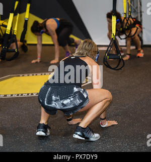 Le ragazze con le cuffie facendo esercizio di fitness in palestra. Foto Stock