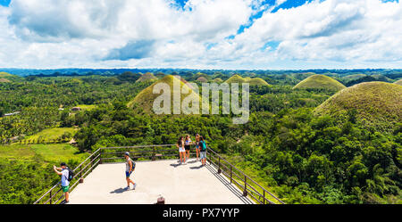 A BOHOL, Filippine - 23 febbraio 2018: persone sullo sfondo delle colline di cioccolato sulla giornata di sole Foto Stock