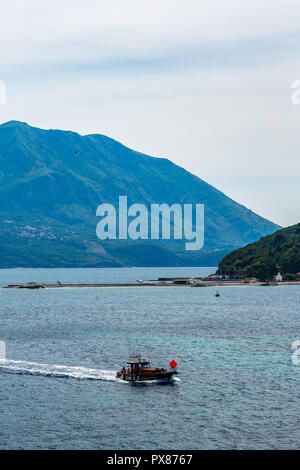 Momenti di pesca, bella primavera mattina blu nei pressi di Budva in Montenegro, vintage in barca e le acque cristalline del Mare Adriatico. Paesaggio verticale Foto Stock