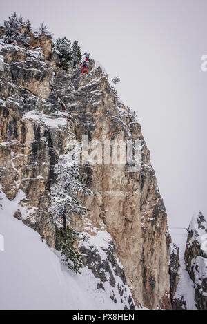 Fuori pista gli sciatori sono praticare arrampicate su roccia. Foto Stock