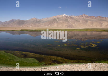 Riflessioni sulle montagne nel bellissimo lago Bulunkul in Alta Valle Gunt nel Pamir Mountains, il Pamir Highway, Gorno Badakshan, Tagikistan Foto Stock