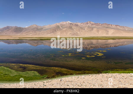 Riflessioni sulle montagne nel bellissimo lago Bulunkul in Alta Valle Gunt nel Pamir Mountains, il Pamir Highway, Gorno Badakshan, Tagikistan Foto Stock