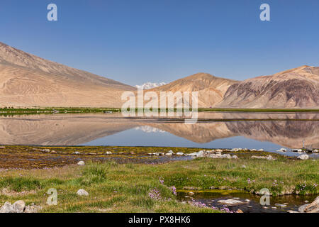 Riflessioni sulle montagne nel bellissimo lago Bulunkul in Alta Valle Gunt nel Pamir Mountains, il Pamir Highway, Gorno Badakshan, Tagikistan Foto Stock