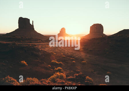 Visualizzazione classica di scenic Monument Valley con il famoso mezzoguanti e Merrick Butte in beautiful Golden. La luce del mattino al sorgere del sole in estate con retro vin Foto Stock