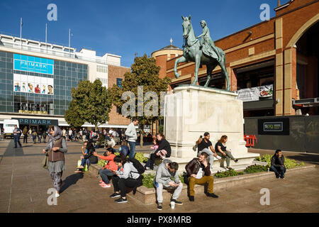 Le persone sedute attorno al Lady Godiva statua sulla Broadgate in Coventry city centre REGNO UNITO Foto Stock