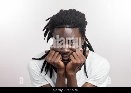 Paura l'uomo faccia con dreadlocks su sfondo bianco Foto Stock