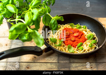 Pasta con le erbe, basilico e salsa di pomodoro servita in una padella Foto Stock