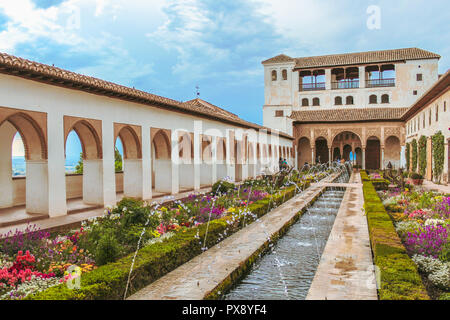 Bellissimo giardino con molti fiori di diversi colori e un corridoio fontana in Granada Generalife, Spagna Foto Stock
