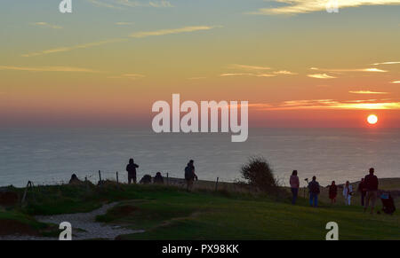 Eastbourne, Regno Unito. Xx oct, 2018. I visitatori avranno vicino al bordo della scogliera a guardare il tramonto da Beachy Head questa sera dopo un altro giorno di caldo clima soleggiato sulla costa sud Credito: Simon Dack/Alamy Live News Foto Stock