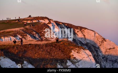 Eastbourne, Regno Unito. Xx oct, 2018. I visitatori avranno vicino al bordo della scogliera a guardare il tramonto da Beachy Head questa sera dopo un altro giorno di caldo clima soleggiato sulla costa sud Credito: Simon Dack/Alamy Live News Foto Stock