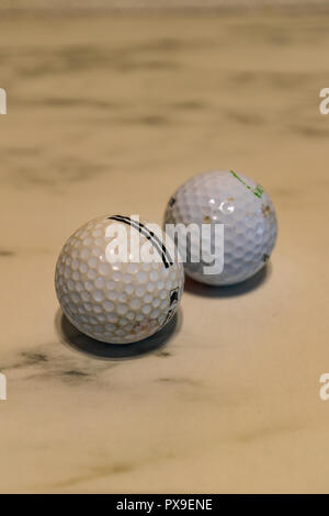 Set di due usato sporco palline da golf su una lastra di marmo closeup Foto Stock