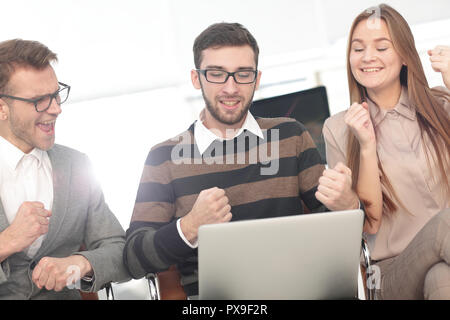 Tre dipendenti eccitati ricevendo buone notizie insieme sulla linea Foto Stock