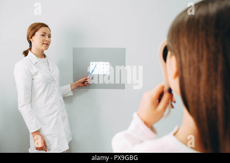 All'ottico optometrista femmina controllando la ragazza vista in cliniche Foto Stock