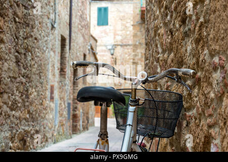 Red vecchia bicicletta con la ruggine in un piccolo vicolo di un borgo medievale Foto Stock