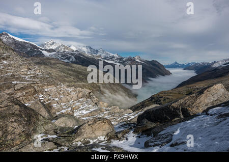 Vista coperto da nuvole e nebbia Stausee lago vicino a Saas Fee nel sud delle Alpi Svizzere dal Monte Moro pass, Italia Foto Stock