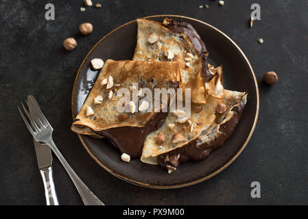 Crepes con cioccolato e nocciole. In casa crespelle sottili per la prima colazione o per dessert. Foto Stock