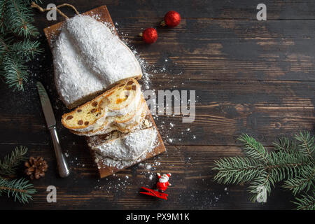 Il Natale lo Stollen su sfondo di legno. Tradizionale festa di Natale la pasticceria dolce. Lo Stollen per Natale. Foto Stock