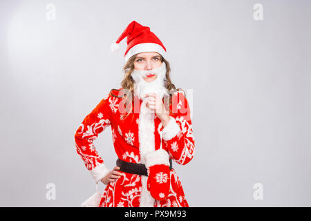 Natale, vacanze e concetto di emozioni - bad arrabbiato donna in costume di santa con barba finta su sfondo bianco con spazio di copia Foto Stock