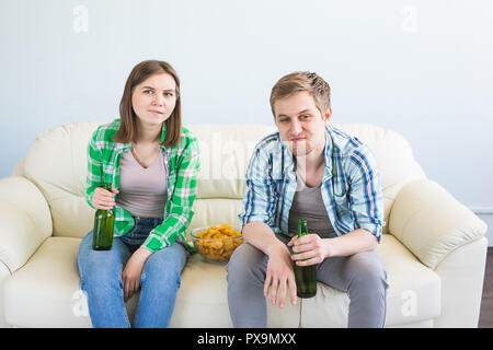 Amici guardare lo sport in TV insieme, bere birra. Ventole il tifo per i loro team. Foto Stock