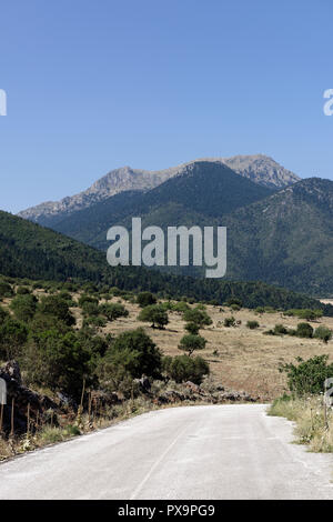 Strada che costeggia il lago di Stymphalia e circondato da paesaggi montuosi, Peloponneso e Grecia. Famoso nel mito come il sito dove Eracle uccise il ma Foto Stock