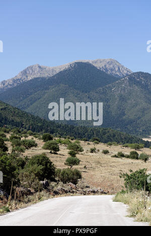 Strada che costeggia il lago di Stymphalia e circondato da paesaggi montuosi, Peloponneso e Grecia. Famoso nel mito come il sito dove Eracle uccise il ma Foto Stock