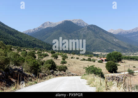 Strada che costeggia il lago di Stymphalia e circondato da paesaggi montuosi, Peloponneso e Grecia. Famoso nel mito come il sito dove Eracle uccise il ma Foto Stock