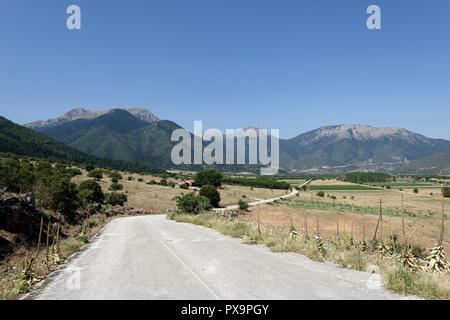 Strada che costeggia il lago di Stymphalia e circondato da paesaggi montuosi, Peloponneso e Grecia. Famoso nel mito come il sito dove Eracle uccise il ma Foto Stock