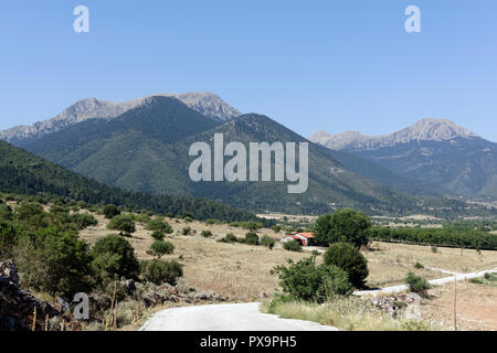 Strada che costeggia il lago di Stymphalia e circondato da paesaggi montuosi, Peloponneso e Grecia. Famoso nel mito come il sito dove Eracle uccise il ma Foto Stock