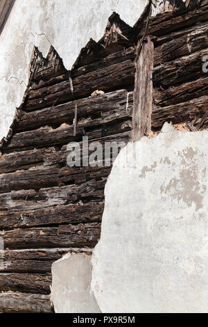 Intonaco rotto su un vecchio edificio di tronchi di legno, che ha cominciato a rot e rompere, primo piano Foto Stock