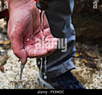 Flusso di acqua pulita versando in mano d'uomo/ mani pulite la cattura di caduta di acqua vicino. Concetto ambientale. Foto Stock