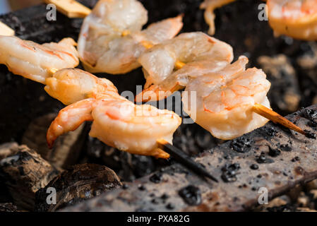 Grigliata di gamberi fritti su gli spiedini sulla griglia metallica Foto Stock