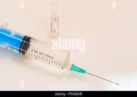 Una siringa e un flaconcino di farmaco sul tavolo vicino Foto Stock