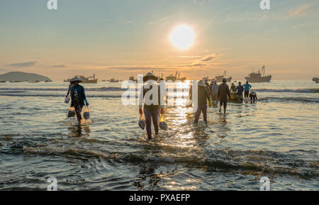 Mercato del pesce di mare di sessione scena persone raccolte all'interno del paniere vendita di pesce, faticoso remare pescatori pesca portata a terra il villaggio di pesca Foto Stock