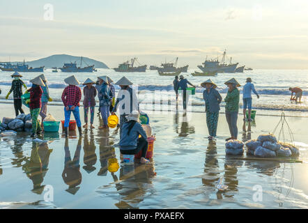 Mercato del pesce di mare di sessione scena persone raccolte all'interno del paniere vendita di pesce, faticoso remare pescatori pesca portata a terra il villaggio di pesca Foto Stock