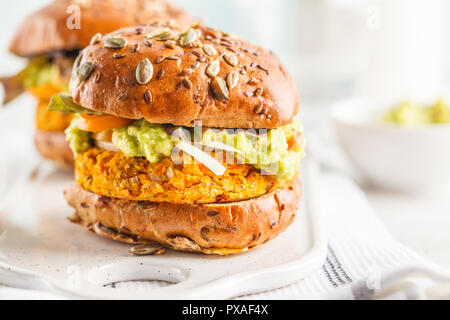 Vegane patata dolce (o zucca) hamburger su sfondo bianco. Hamburger vegetali, avocado, verdure e focacce. Pulire mangiare, impianti alimentari a base di concetto. Foto Stock