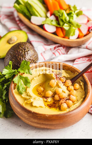 Avocado hummus in una ciotola di legno con verdure. Sano cibo vegan concetto. Foto Stock