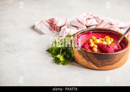 Hummus di barbabietole in una ciotola di legno con verdure. Impianto basato dieta concetto. Foto Stock