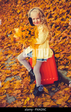 Bambina con capelli biondi in autunno sfondo Foto Stock