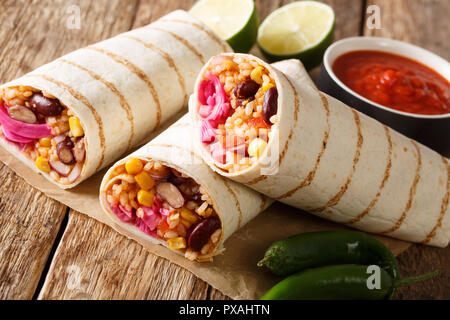 Delizioso vegetariano speziato burrito con riso e verdure vicino sul tavolo orizzontale. Foto Stock