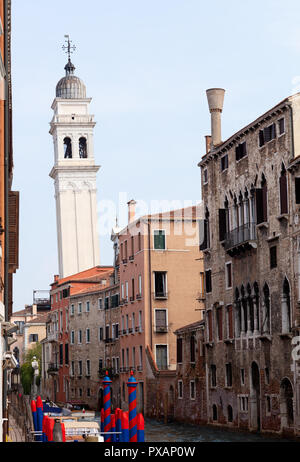 White torre pendente a Venezia da uno stretto canale con vecchi edifici nella parte anteriore Foto Stock