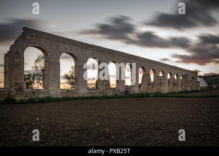 Vecchio Acquedotto Gozo, costruito dagli inglesi per il trasporto di acqua da Għar Ilma nei limiti della Kerċem. Acquedotto rovine. durante il tramonto con esposizione lunga shot w Foto Stock