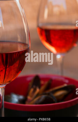 Due di vino rosso in bicchieri e le cozze in una piastra sul tavolo. Foto Stock