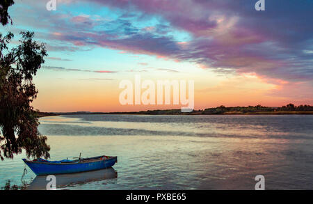 Barca in un fiume al tramonto . Foto Stock