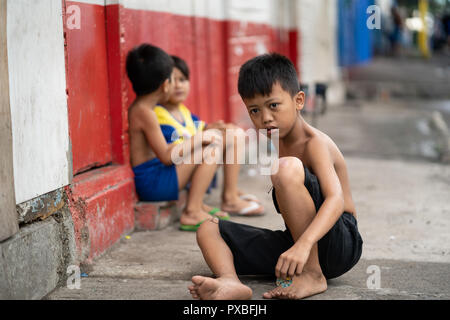 Lo sguardo fisso di un giovane ragazzo filippino senza scarpe cercando superato il fotografo ,Cebu City, Filippine